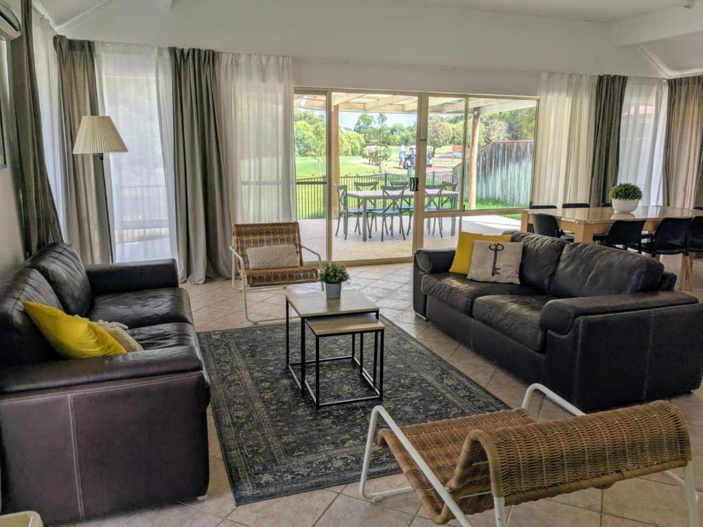 a living room with couches and a table at Stableford Cottage Holiday Home Dunsborough in Dunsborough