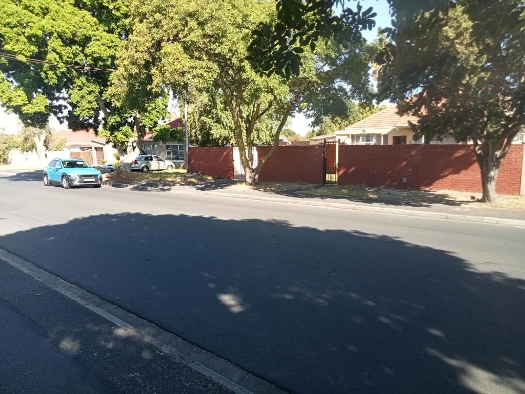 a blue car parked on the side of a street at ATHOME BELLVILLE Chrismar in Cape Town