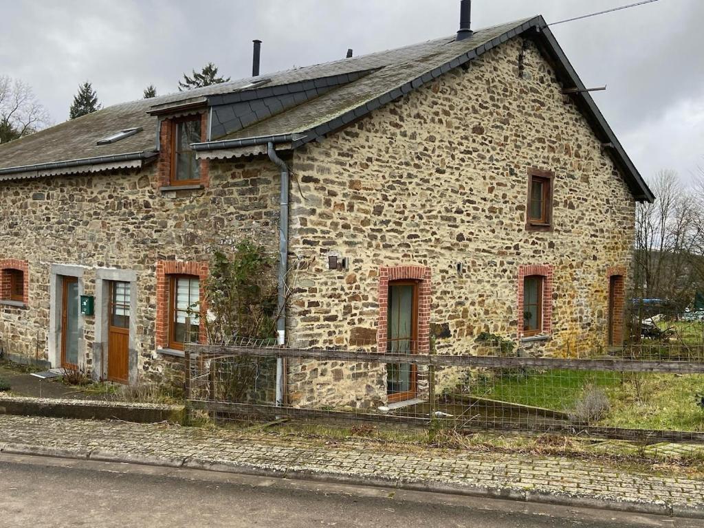 una vecchia casa in pietra sul lato della strada di Le Refuge de Libin a Libin