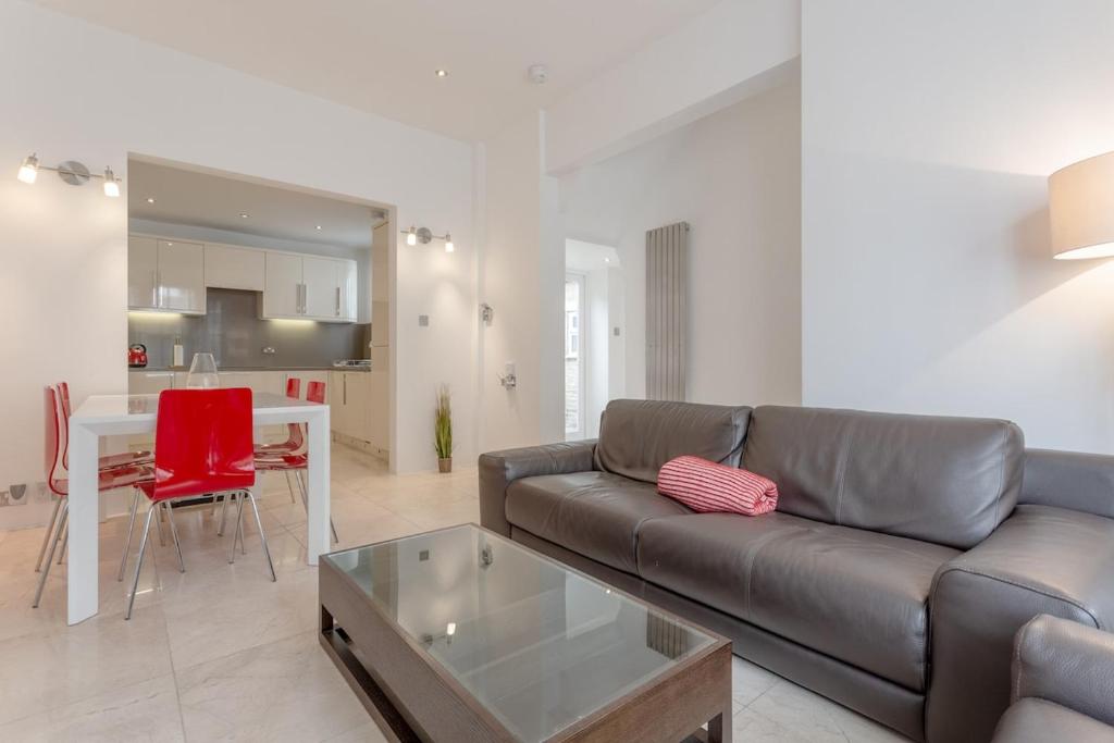 a living room with a couch and a table at Bright Modern Large 1 Bed Flat in Battersea Clapham Junction in London