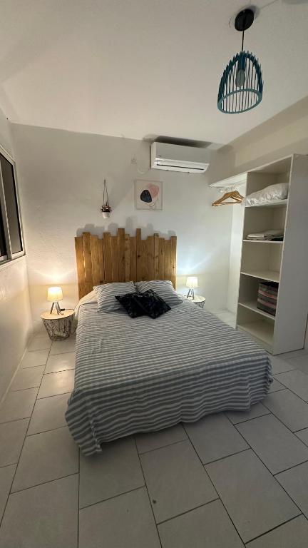 a bedroom with a large bed with a wooden headboard at P'tii repos Soleil in Sainte-Anne