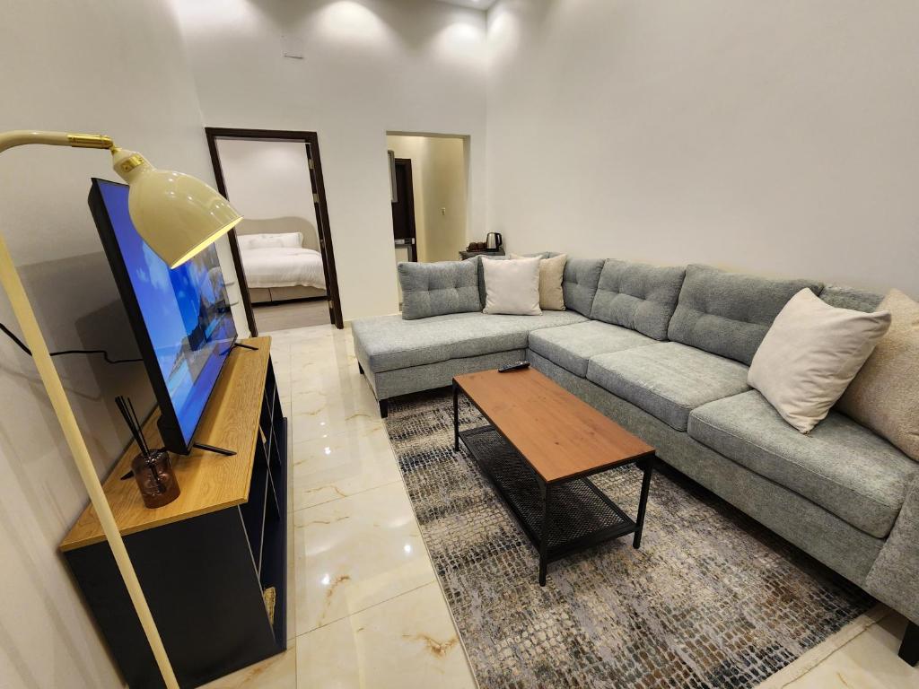 a living room with a couch and a tv at نجدية - كافد وبوليفارد الرياض in Riyadh