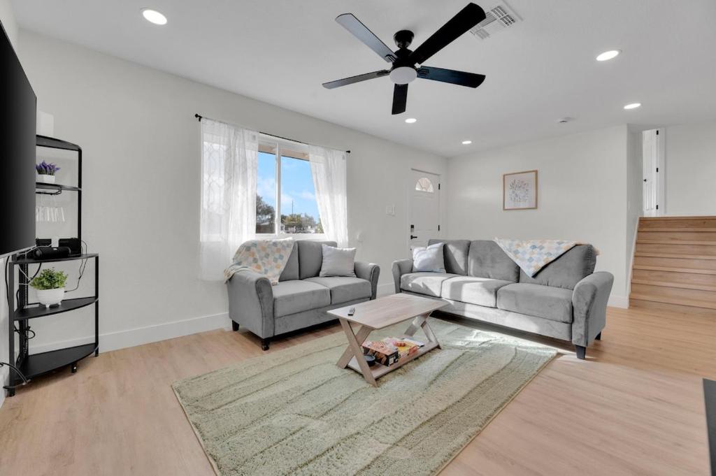 ein Wohnzimmer mit 2 Sofas und einem Deckenventilator in der Unterkunft Modern 4BR3Ba Home with Pool and Fire Pit in Phoenix