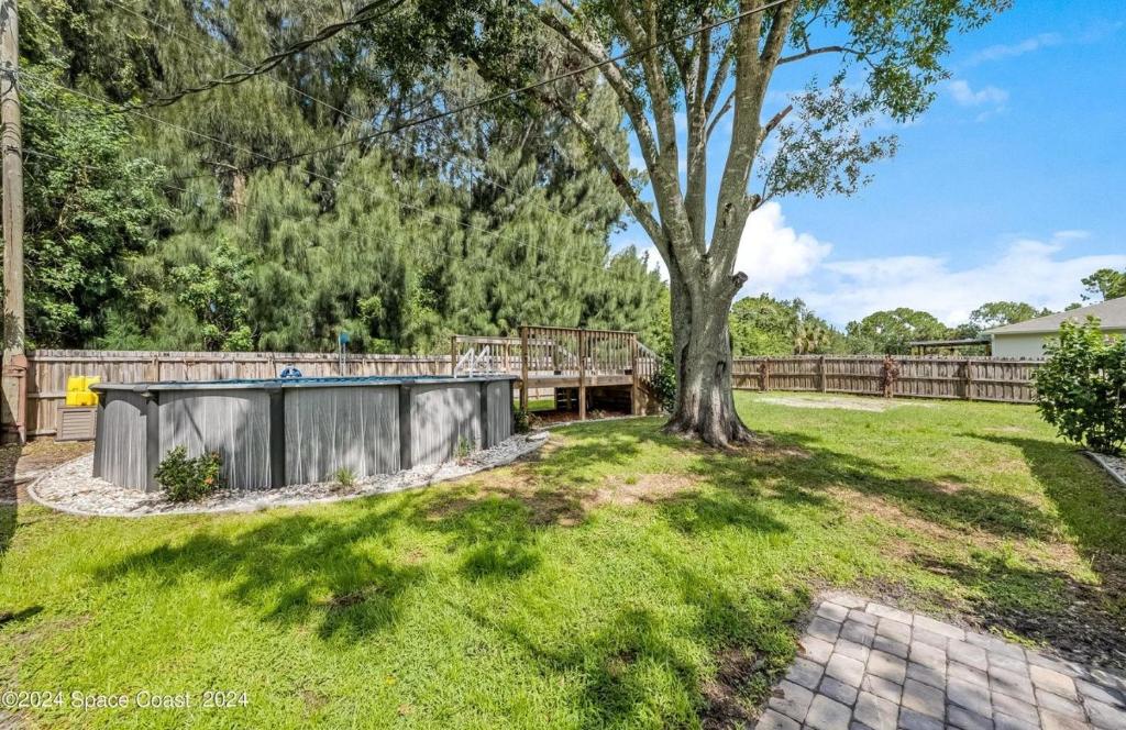 a yard with a tree and a fence at Kris Jordan C in Palm Bay