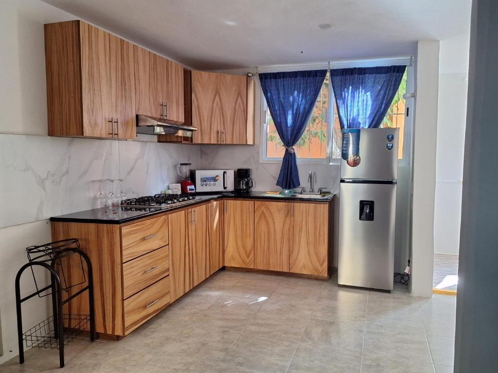 a kitchen with wooden cabinets and a refrigerator at Departamento Chahué in Santa Cruz Huatulco