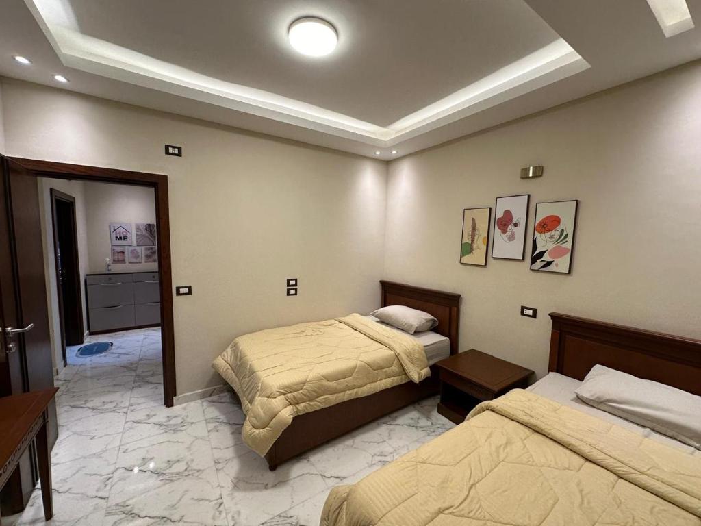 a hotel room with two beds and a bathroom at شقة فندقية في المهندسين جامعة الدول in Cairo