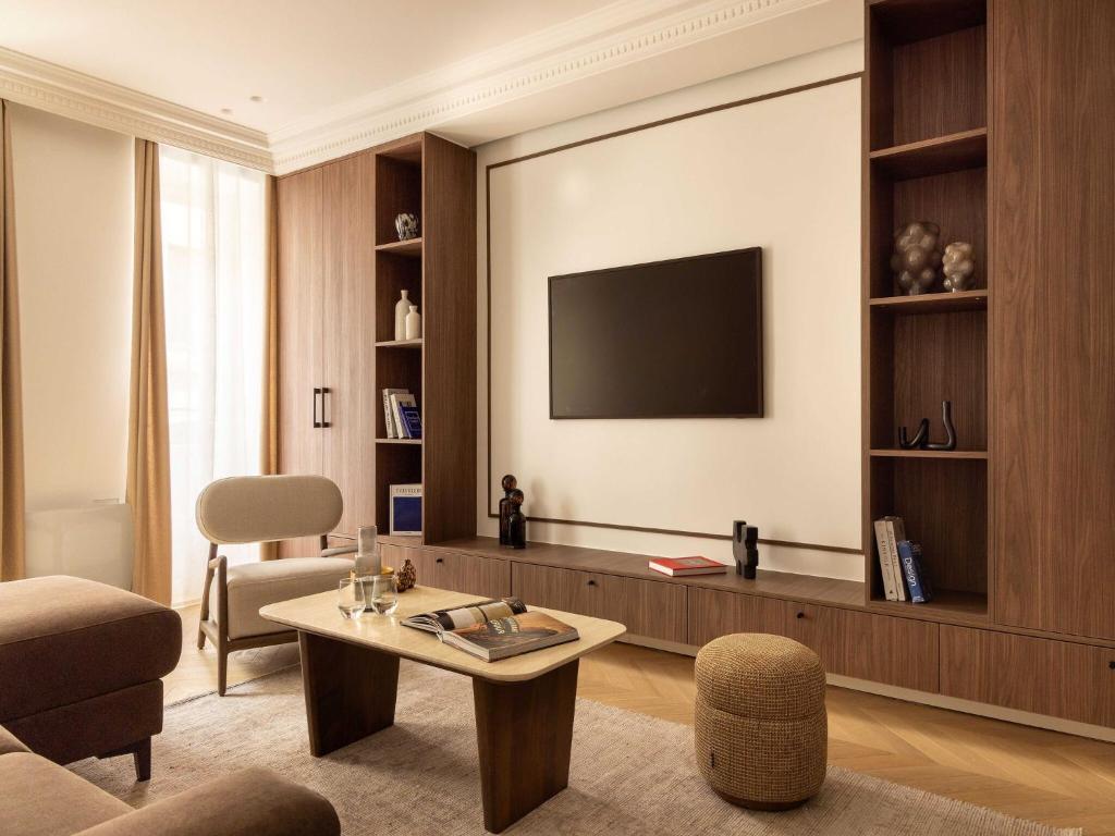 un salon avec une télévision sur un mur dans l'établissement Elegant appt- AC-2BR-6P- Musée du Louvre, à Paris