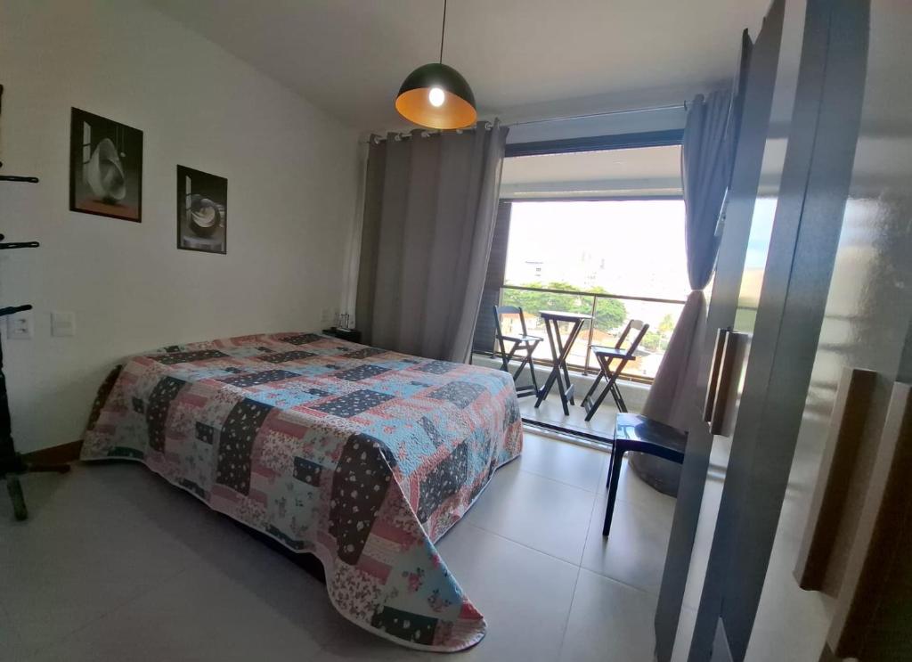 a bedroom with a bed and a view of a balcony at ZN Studio Barra in Salvador