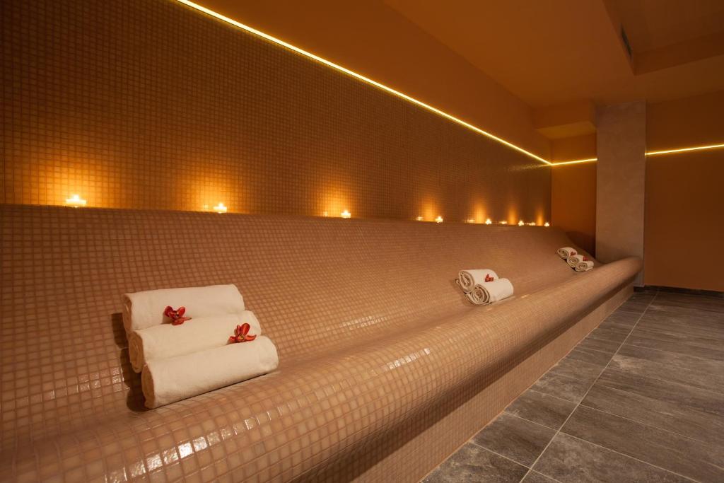 a bathroom with towels on a wall with lights at Blue Waves Resort in Malinska