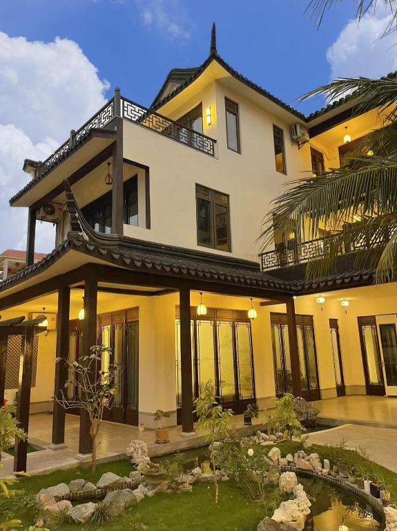 陵水Lanyuan Xiaozhu-New Chinese Courtyard B&B的前面设有花园的大房子