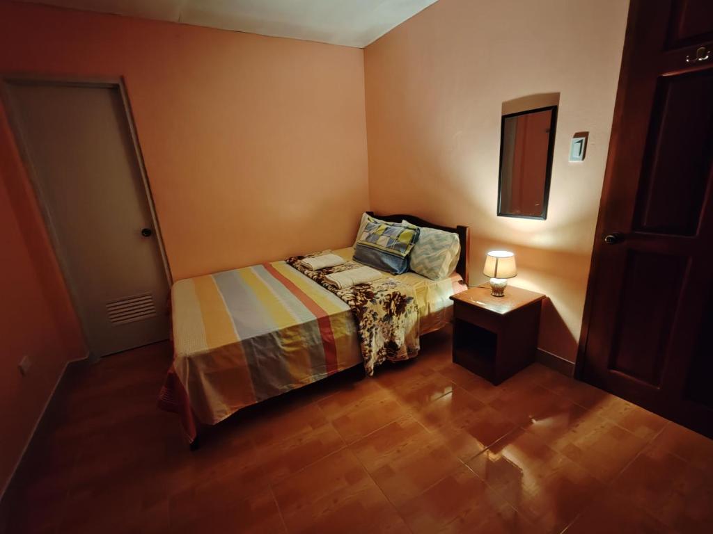 une petite chambre avec un lit et une table de chevet dans l'établissement TGH 2 The Garden Villa The Guest House Badian, à Dagatan