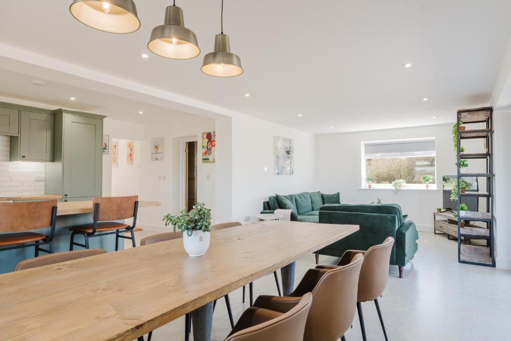 a living room with a large wooden table and chairs at Gatekeepers Cottage - Idyllic 4 Bed Rural Escape! in Cropthorne