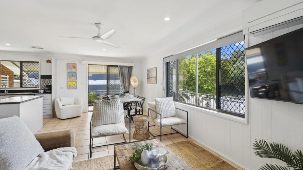 una sala de estar con un sofá y una mesa en Barefoot On First - Pool, Beach, Family - Friendly, en Sawtell