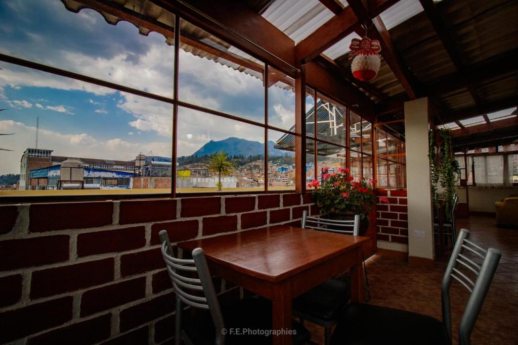 una stanza con tavolo e sedie e una grande finestra di Hatun Wasi Huaraz a Huaraz