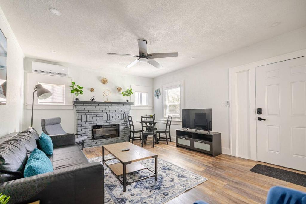 un soggiorno con divano e camino di Downtown Hideaway 1-Bedroom Bungalow a St Petersburg