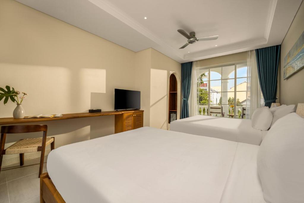 Postel nebo postele na pokoji v ubytování Spring Breeze Hotel Hoi An