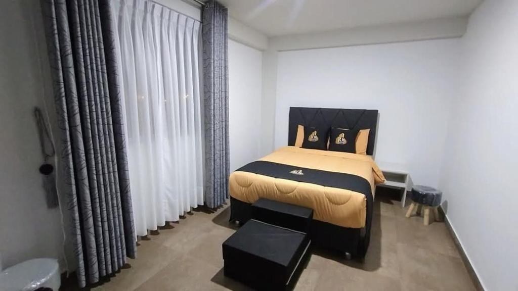 una camera da letto con un letto grande in una stanza bianca di Hotel MAXIMUM COMFORT FCA a Salinas