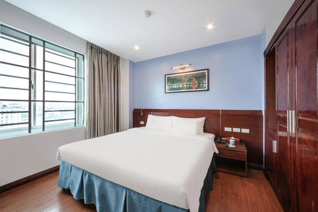 een slaapkamer met een wit bed en een groot raam bij A25 Hotel - 63A Phương Liệt in Hanoi