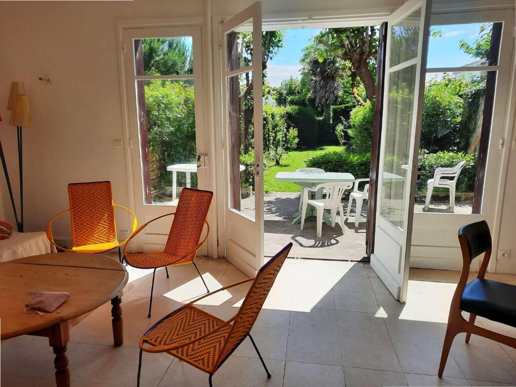 a living room with a table and chairs and a patio at Maison familiale rénovée pour 13 pers. à Royan, proche plage - FR-1-494-204 in Royan