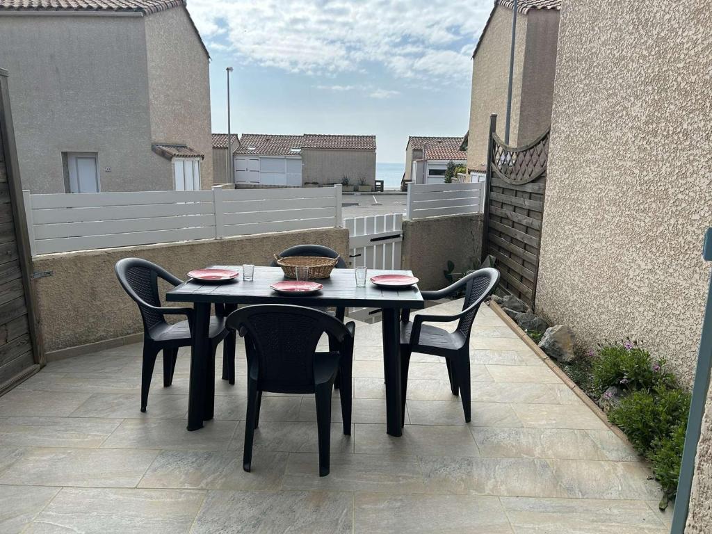 une table et des chaises assises sur une terrasse avec balcon dans l'établissement Maison 2 pièces mezzanine à Saint Pierre la Mer, terrasse et parking privé - FR-1-229D-154, à Fleury