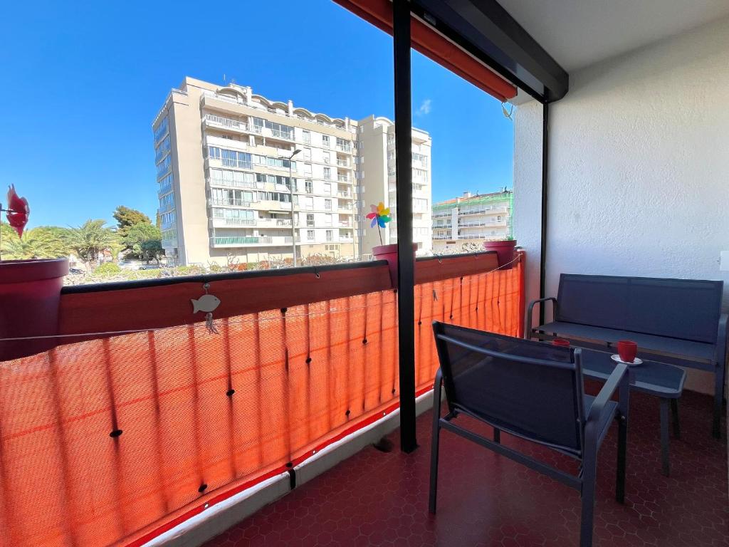 - un balcon avec deux chaises et une vue sur un bâtiment dans l'établissement Appartement T2 Saint-Cyprien près du port avec parking - FR-1-309-500, à Saint-Cyprien