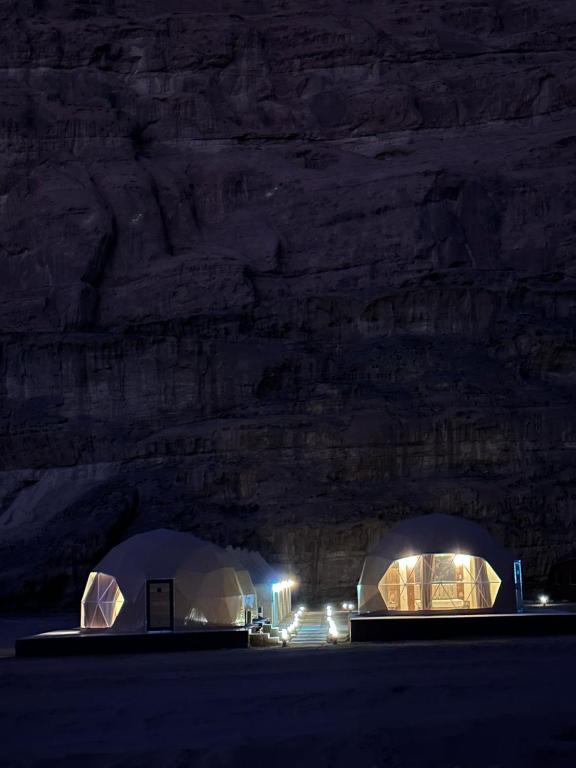 two domes in a field at night with lights at Wadi Rum Salman camp in Wadi Rum