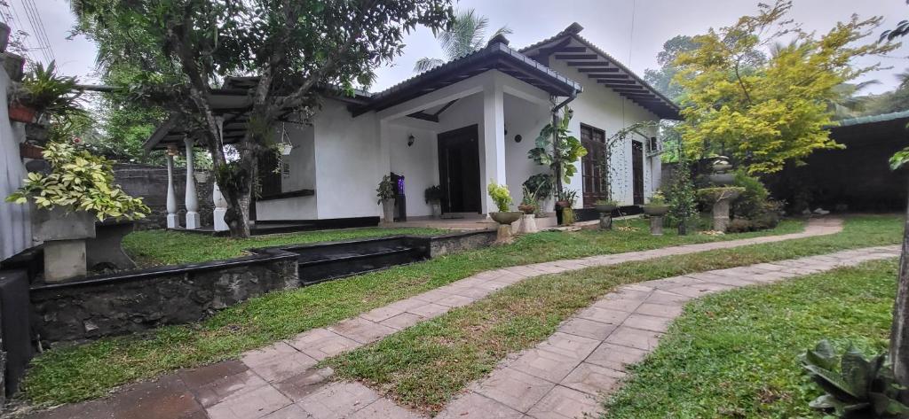 a house with a walkway in front of it at Villa De Wick's in Kimbulapitiya