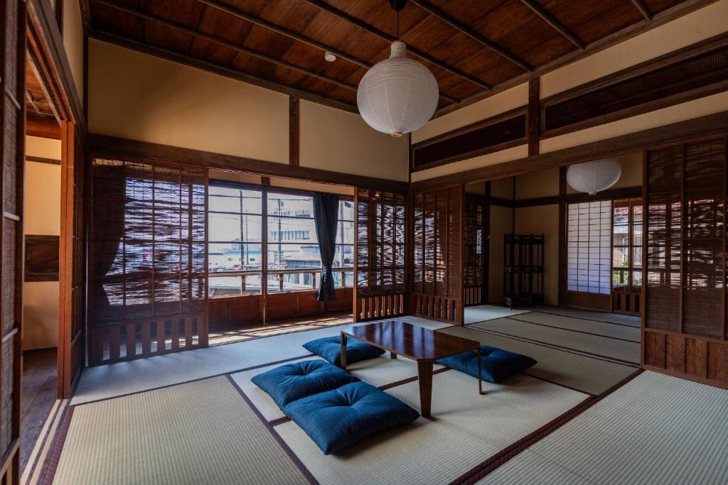 a room with a table and blue chairs and windows at R-house 5th - Vacation STAY 17834 in Numazu