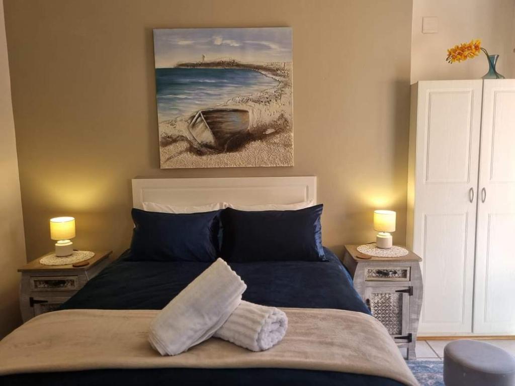 1 dormitorio con 1 cama con 2 lámparas y una pintura en la pared en Boschendal Guesthouse, en Kimberley