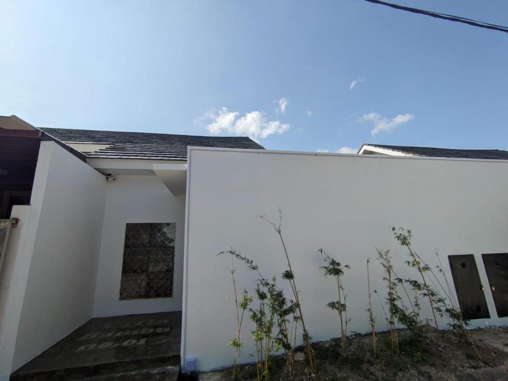 a white wall with plants in front of it at Villa Bambu Batam in Bokor