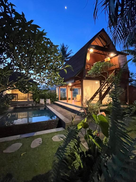 a villa with a swimming pool at night at Shri Wedari Private Pool with Ricefield View in Tampaksiring