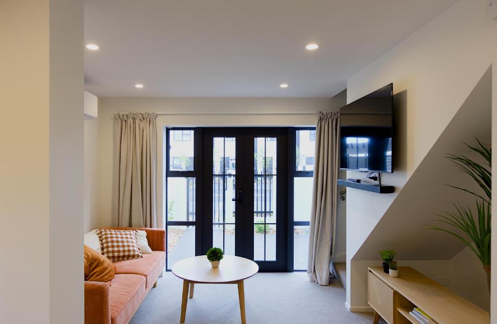a living room with a couch and a table at Modern Townhouse, Prime Location, Carpark in Christchurch