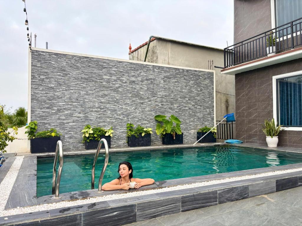 a woman is laying in a swimming pool at TuTu's Homestay Phong Nha in Phong Nha