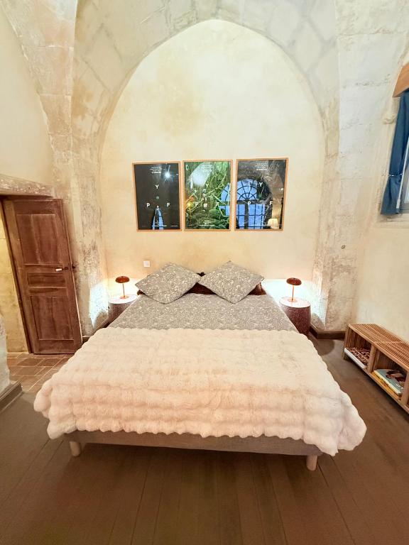 une chambre avec un grand lit dans une pièce dans l'établissement Les écuries de Lestang-Parade, à Arles