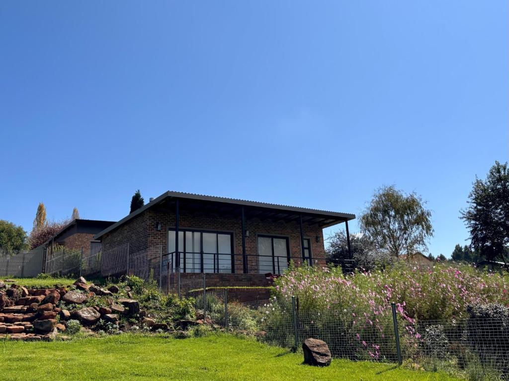 a house with a garden in front of it at Mika Self Catering Cottage in Dullstroom