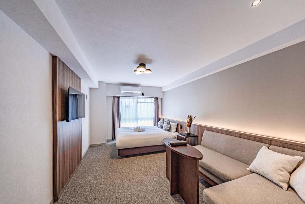 a hotel room with a bed and a couch at Apartment Hotel 11 Shinsaibashi 5 in Osaka