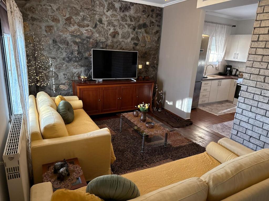 a living room with a couch and a flat screen tv at Οικία τζιβαέρι in Edessa