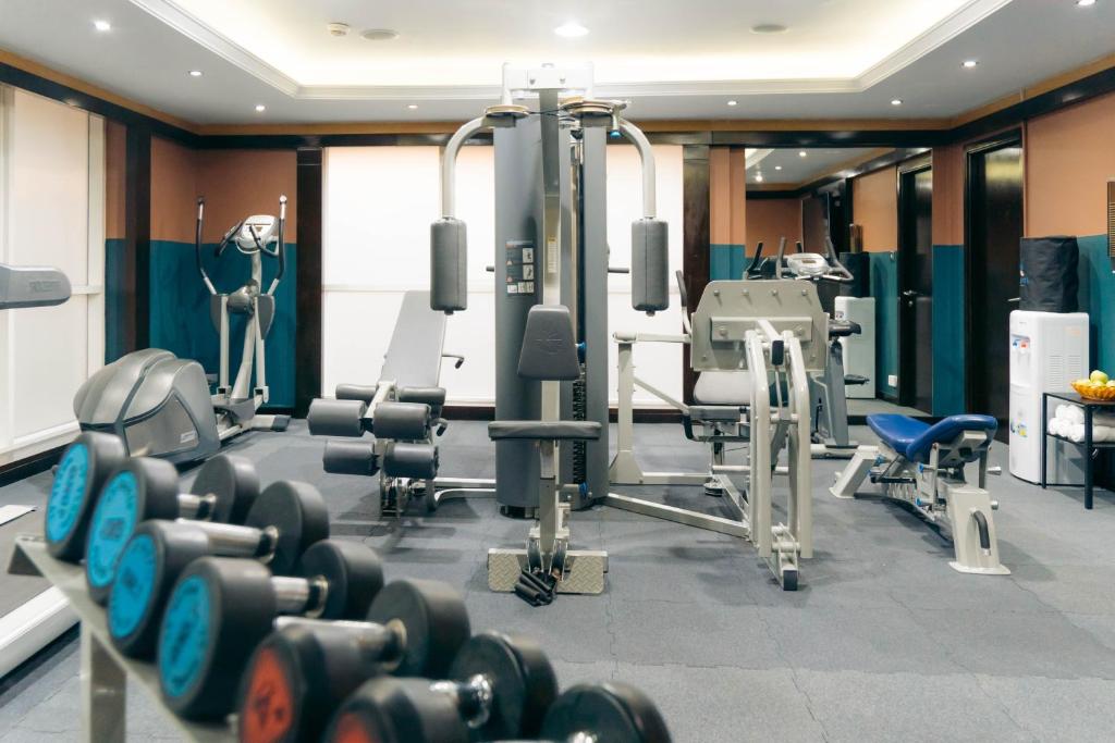 a gym with dumbbells and other equipment at Kingsgate Hotel by Millennium in Abu Dhabi