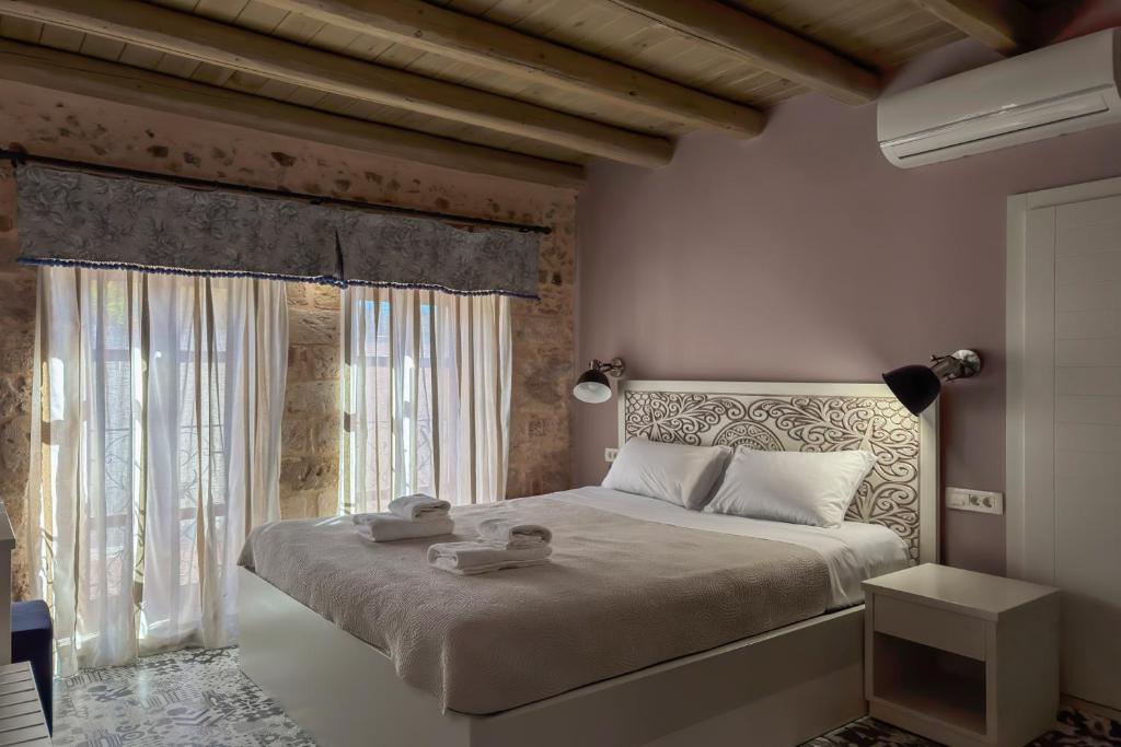 a bedroom with a large bed and a window at Vetus Oppidum Boutique Guesthouse in Chania