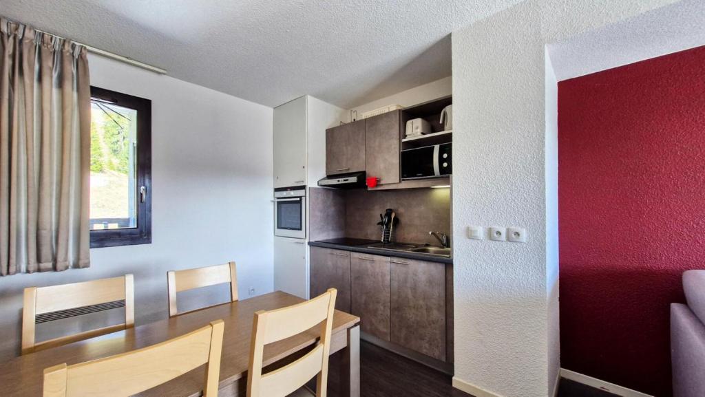 une cuisine et une salle à manger avec une table et des chaises dans l'établissement Résidence Les Terrasses De Veret - Appartement confortable · Au pied des pistes · Piscine · Spa · Parking inclus MAE-7391, à Flaine