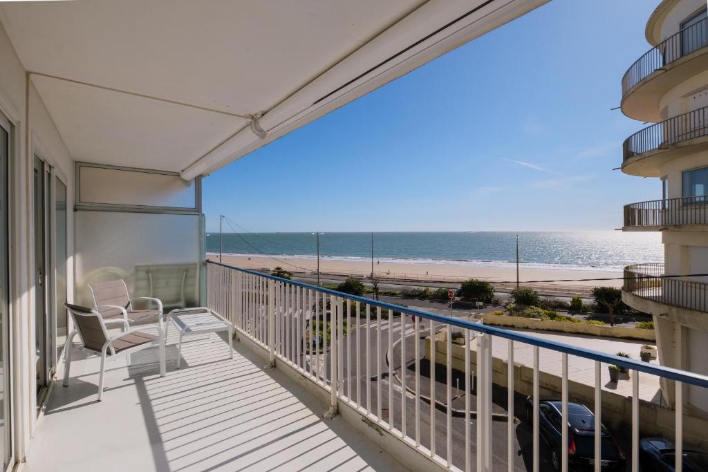 d'un balcon avec des chaises et une vue sur la plage. dans l'établissement L'Ancre - Spacieux T4 élégant et lumineux vue mer, à La Baule