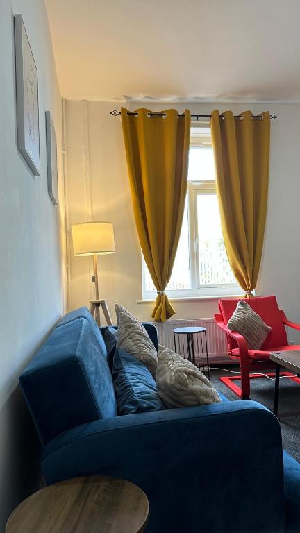 a blue couch in a living room with a window at The Ol-Mumps Cozy Corner in Oldham