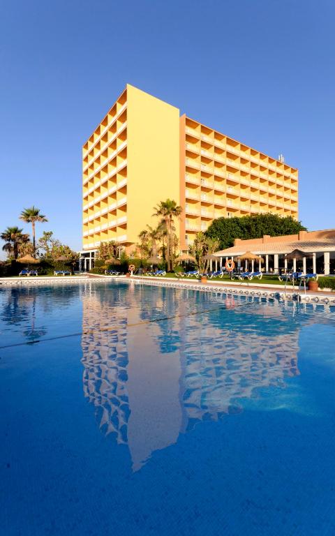 un hotel con una gran piscina frente a un edificio en Sol Guadalmar, en Málaga