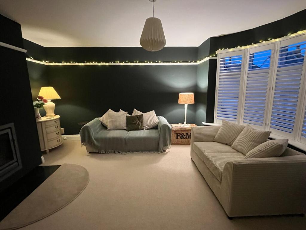 a living room with a couch and a chair at 4 Bedroom Detached House Sleeps 7 in Ipswich