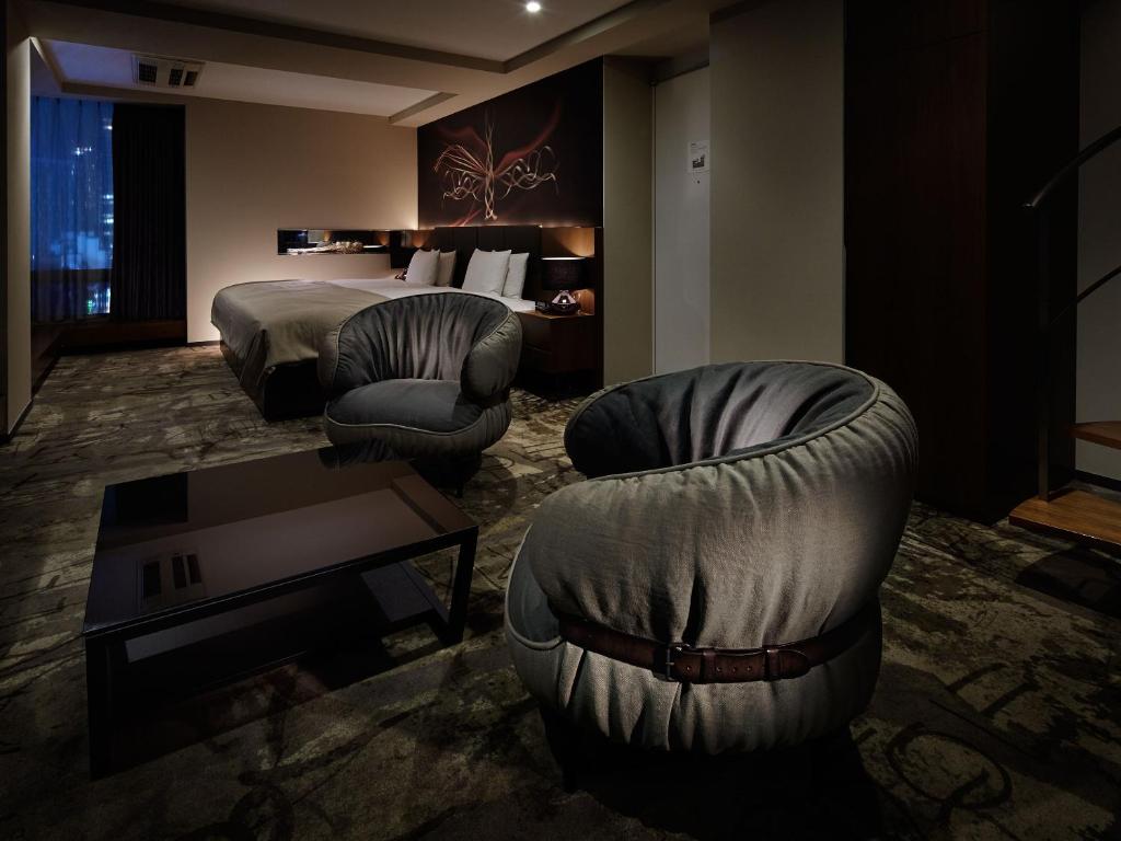 pokój hotelowy z 2 krzesłami i łóżkiem w obiekcie Akasaka Granbell Hotel w Tokio