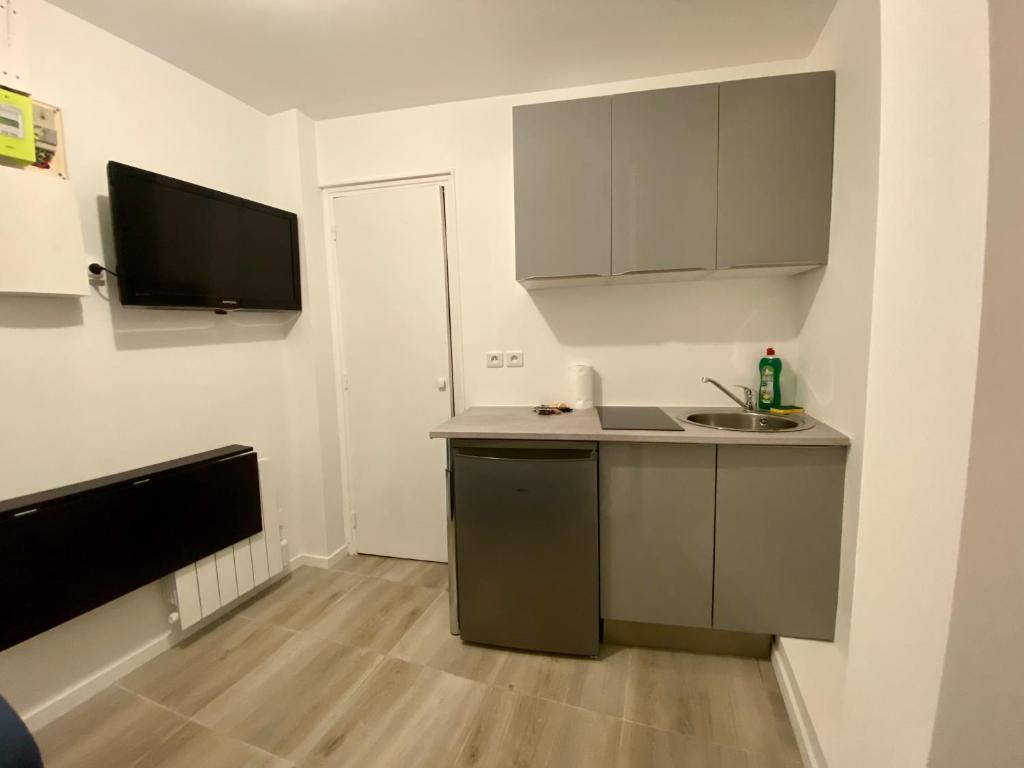 une petite cuisine avec un évier et un comptoir dans l'établissement Petit Cocon au Centre de Rouen - 027, à Rouen