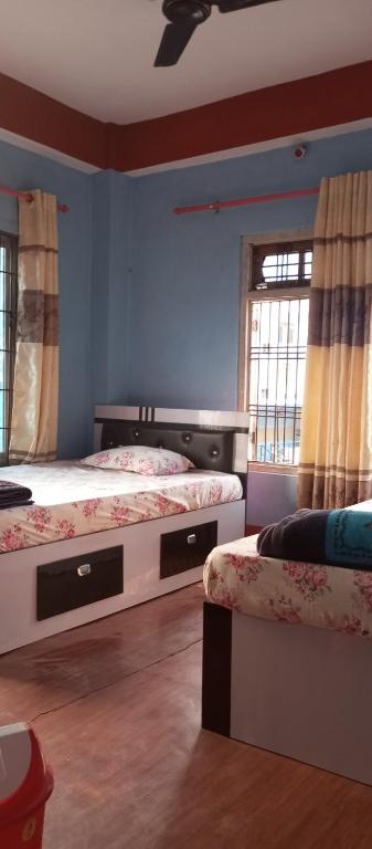 una camera da letto con due letti e una finestra di Anil Guest house and khajaghar a Rāmechhāp
