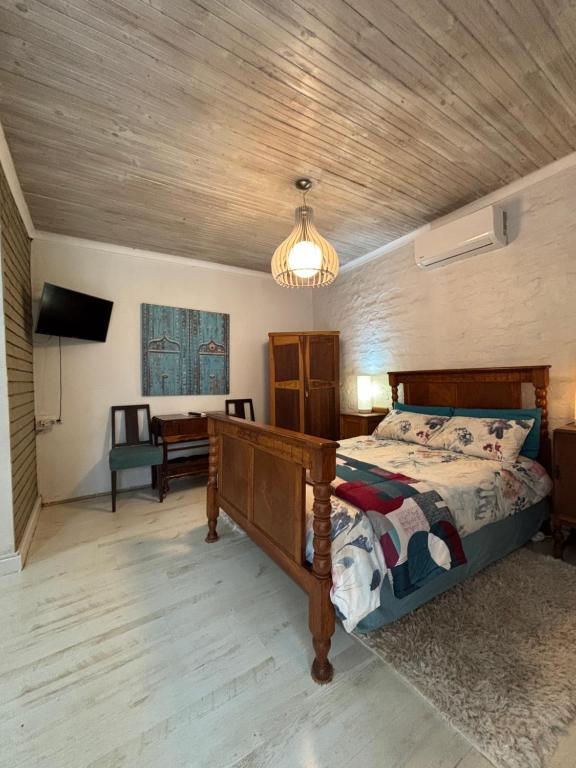 a bedroom with a bed and a wooden ceiling at The Vineyard East in Joostenberg Vlakte