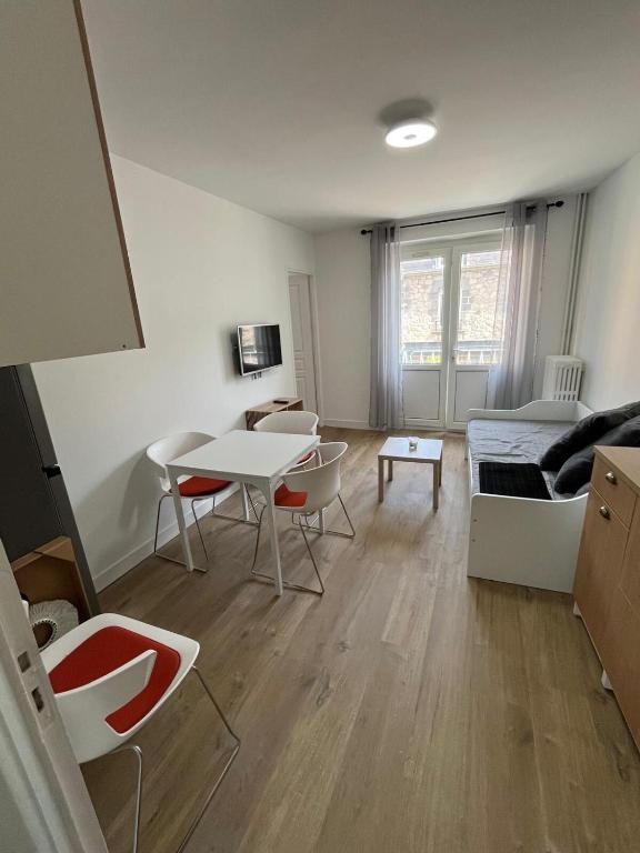 a living room with a table and a couch at Les balcons du 115 BIS - Appartement standing in La Bourboule
