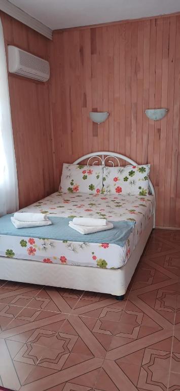 a bedroom with a bed with flowers on it at Selin Pansiyon in Kemer